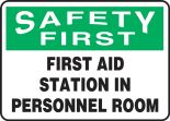 Safety Sign, Header: SAFETY FIRST, Legend: FIRST AID STATION IN PERSONNEL ROOM