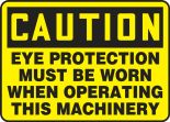 Safety Sign, Header: CAUTION, Legend: CAUTION EYE PROTECTION MUST BE WORN WHEN OPERATING THIS MACHINERY