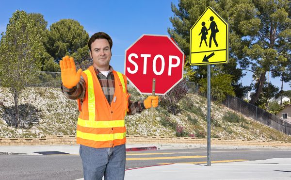 Crossing guard in vest with paddle sign