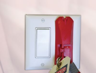 STOPOUT® Wall lockout switch attached to a lightswitch