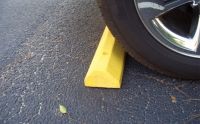 Parking block marquee image of tire near block.